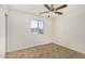 Cozy bedroom featuring a ceiling fan, tile flooring, and a bright window at 4526 W Mission Ln, Glendale, AZ 85302