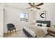 A cozy bedroom features a ceiling fan, a comfortable chair, and a sunlit window view at 4526 W Mission Ln, Glendale, AZ 85302
