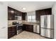 Well-lit kitchen featuring stainless steel appliances, dark cabinetry, and neutral countertops at 4526 W Mission Ln, Glendale, AZ 85302