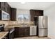 Bright kitchen showcasing stainless appliances, dark cabinets, and a tiled backsplash at 4526 W Mission Ln, Glendale, AZ 85302