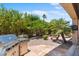 Outdoor living space features a stainless steel grill, tropical landscaping, and stone covered ground at 4528 E Donato Dr, Gilbert, AZ 85298