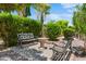 Outdoor patio area featuring metal benches and mature landscaping and trees at 4528 E Donato Dr, Gilbert, AZ 85298