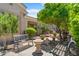 Inviting backyard space features metal benches and mature landscaping and trees at 4528 E Donato Dr, Gilbert, AZ 85298