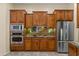 Well-equipped kitchen featuring stainless steel appliances, granite countertops, and wooden cabinets at 4528 E Donato Dr, Gilbert, AZ 85298