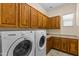 Well-equipped laundry room featuring modern washer and dryer, and ample cabinet space for supplies at 4528 E Donato Dr, Gilbert, AZ 85298