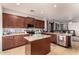 Open kitchen with granite island, stainless steel appliances, and rich wood cabinetry at 5139 S Marble St, Gilbert, AZ 85298
