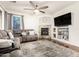 Inviting living room with a ceiling fan, stone fireplace, and a comfortable gray couch at 5139 S Marble St, Gilbert, AZ 85298