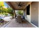 View of the covered patio with ceiling fan, outdoor table, chairs, and a glimpse of the pool at 5139 S Marble St, Gilbert, AZ 85298