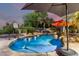 Beautiful backyard pool featuring a basketball hoop, waterfall feature, and lush landscaping at 5139 S Marble St, Gilbert, AZ 85298