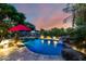 Inviting backyard pool featuring a rock waterfall, mature trees, and colorful sunset views at 5139 S Marble St, Gilbert, AZ 85298