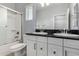 Well-lit bathroom featuring double sinks, white cabinets, a shower/tub combo with glass doors at 5550 N 16Th St # 166, Phoenix, AZ 85016