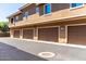 Row of multi-car garages on tan building. Garages are equipped with stylish brown doors and lighting at 5550 N 16Th St # 166, Phoenix, AZ 85016