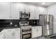 Modern kitchen featuring stainless steel appliances, sleek black countertops, and bright white cabinetry at 5550 N 16Th St # 166, Phoenix, AZ 85016