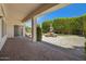 A large back patio with sliding door access and a stone picnic table with umbrella in a landscaped yard at 592 W Harvard Ave, Gilbert, AZ 85233