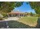 Expansive backyard featuring a lush lawn, patio area, mature trees, and a stone picnic table at 592 W Harvard Ave, Gilbert, AZ 85233