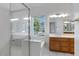Bright bathroom featuring a glass-enclosed shower, tile floors, and wooden vanity with a view to the outside at 592 W Harvard Ave, Gilbert, AZ 85233