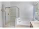 Bright bathroom features a glass enclosed shower, soaking tub and a window that provides natural light at 592 W Harvard Ave, Gilbert, AZ 85233