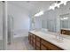 Bright bathroom features a dual sink vanity with wood cabinets, and a separate glass enclosed shower and soaking tub at 592 W Harvard Ave, Gilbert, AZ 85233