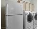 Well-equipped laundry room with front-load washer and dryer and overhead cabinets for storage at 592 W Harvard Ave, Gilbert, AZ 85233