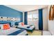 Bright, inviting bedroom with blue accent walls and modern decor, with ample natural light from a window at 6945 E Osborn Rd # B, Scottsdale, AZ 85251