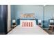 Bright bedroom featuring blue accent wall, minimalist decor, and side tables with matching lamps at 6945 E Osborn Rd # B, Scottsdale, AZ 85251