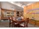 A dining room with wood walls, a large oval table, eight chairs, and a window overlooking the backyard at 743 W Ocotillo Rd, Phoenix, AZ 85013
