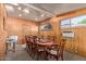 A dining room featuring wood walls, large oval table, eight chairs, and a window at 743 W Ocotillo Rd, Phoenix, AZ 85013