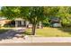 Well-maintained home featuring a covered porch, mature tree and manicured lawn at 743 W Ocotillo Rd, Phoenix, AZ 85013