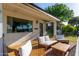 Charming front porch with white brick, wooden furniture, and well manicured foliage at 743 W Ocotillo Rd, Phoenix, AZ 85013