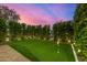 Lush backyard featuring a putting green with manicured hedges and ambient lighting at 8038 E Clarendon Ave, Scottsdale, AZ 85251