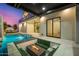 Backyard view showcasing pool, outdoor fire pit with seating, and sliding glass door to the home's interior at 8038 E Clarendon Ave, Scottsdale, AZ 85251