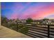 Balcony view showcasing a neighborhood street with green trees against a vibrant, colorful sunset sky at 8038 E Clarendon Ave, Scottsdale, AZ 85251