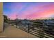 Balcony view showcasing a neighborhood street with green trees and a mountain against a vibrant, colorful sunset sky at 8038 E Clarendon Ave, Scottsdale, AZ 85251