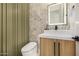 Stylish bathroom with a vessel sink, wood vanity, decorative wall, and modern toilet at 8038 E Clarendon Ave, Scottsdale, AZ 85251