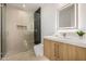 Modern bathroom featuring a glass-enclosed shower and a vanity with a marble countertop and lighted mirror at 8038 E Clarendon Ave, Scottsdale, AZ 85251