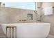 Luxurious bathroom showcasing marble walls and floors and a modern bathtub at 8038 E Clarendon Ave, Scottsdale, AZ 85251