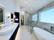Luxurious bathroom features double vanity, marble accents, a glass shower, and a modern soaking tub at 8038 E Clarendon Ave, Scottsdale, AZ 85251