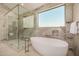 Luxurious bathroom with a standalone tub and walk-in glass shower at 8038 E Clarendon Ave, Scottsdale, AZ 85251