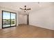 Bright bedroom with sleek hardwood flooring, a sliding door, and a ceiling fan for added comfort at 8038 E Clarendon Ave, Scottsdale, AZ 85251