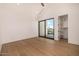 Bright bedroom with hardwood floors, sliding glass doors to a balcony, and a walk-in closet at 8038 E Clarendon Ave, Scottsdale, AZ 85251