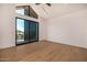 Bright bedroom with hardwood floors, ceiling fan, and a large glass sliding door to the outdoor patio at 8038 E Clarendon Ave, Scottsdale, AZ 85251