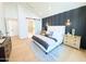 Bright bedroom with vaulted ceilings, decorative headboard, ensuite bathroom and light wood floors at 8038 E Clarendon Ave, Scottsdale, AZ 85251