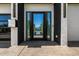 Modern home featuring a sleek, glass front door with a contemporary black and white facade at 8038 E Clarendon Ave, Scottsdale, AZ 85251