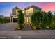 Beautiful two-story modern home with professional landscaping, a black framed garage, and stylish design at 8038 E Clarendon Ave, Scottsdale, AZ 85251