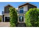 Elegant two-story home boasting modern architecture, manicured landscaping, and a chic black garage at 8038 E Clarendon Ave, Scottsdale, AZ 85251