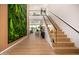 Stunning hallway with a living green wall and open staircase with glass railings at 8038 E Clarendon Ave, Scottsdale, AZ 85251