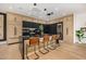 Modern kitchen with a sleek island, light wood cabinets, black countertops, and state-of-the-art appliances at 8038 E Clarendon Ave, Scottsdale, AZ 85251
