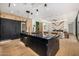 Modern kitchen with a dark island, integrated appliances, and an open layout at 8038 E Clarendon Ave, Scottsdale, AZ 85251