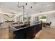 Open-concept kitchen with a dark marble island, leading to the living and dining areas, perfect for entertaining at 8038 E Clarendon Ave, Scottsdale, AZ 85251