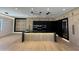 Modern kitchen with stainless steel appliances, black countertops and an island with a built in sink at 8038 E Clarendon Ave, Scottsdale, AZ 85251